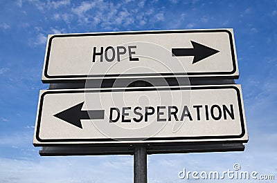 White two street signs with arrow on metal pole with word hope and desperation Stock Photo