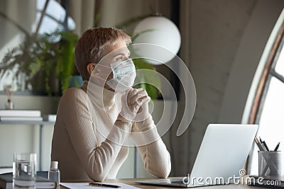 Hopeful female employee in protective gear praying Stock Photo