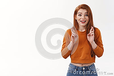 Hopeful happy cheerful urban redhead girl wear cropped sweater cross fingers good luck smiling anticipating positive Stock Photo