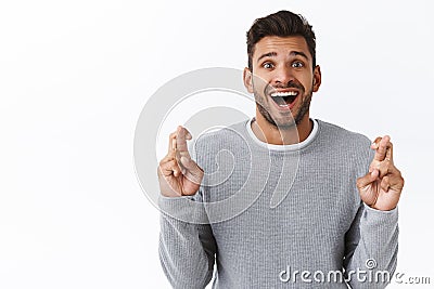 Hopeful lucky excited guy feeling good fortune will come, cross fingers good luck, smiling with excitement and Stock Photo