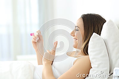 Hopeful woman checking pregnancy test at home Stock Photo