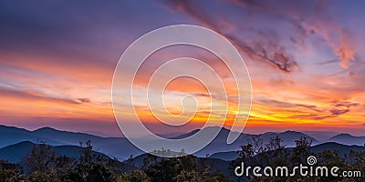 Horizon's Embrace: Mountains Bathed in Sunset's Golden Light. Stock Photo