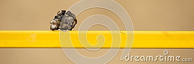 Horizontal background with molten piece of plastic on a yellow metal structure Stock Photo