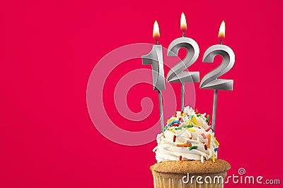 Horizontal birthday card with cupcake - Burning candle number 122 Stock Photo