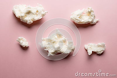 Horizontal image of tufts of homemade white candy floss, on pink background Stock Photo