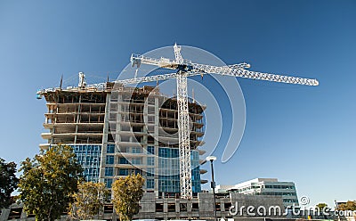 Horizontal mage of White crane towers at a large construction site for a condominium complex Stock Photo