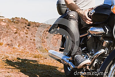 Horizontal partial view of young biker riding a custom motorcycle Stock Photo