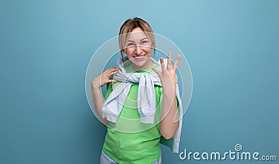 horizontal photo of a blond positive bright girl in a casual outfit on a blue background with copy space Stock Photo