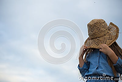 Horizontal photo of a six year old girl who pulled her hat over her eyes Stock Photo