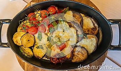 Horizontal picture of an assortment of baked vegetables with provolone cheese melted on top. Stock Photo