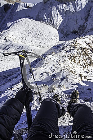 Horizontal picture of mountaineer holding an ice ax and using crampons to walk on the ice of a glacier in Iztaccihuatl - Stock Photo