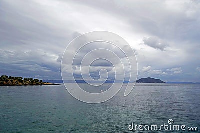 Horizontal shot. Empty beach in the evening at sunset. . Silhouettes and coastline. Sea bright sky. Greece Stock Photo