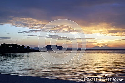Horizontal shot. Empty beach in the evening at sunset. . Silhouettes and coastline. Sea bright sky. Stock Photo