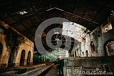 Horizontal shot of a grey brick-walled building interior with a partially collapsed roof Stock Photo