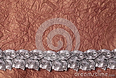 Horizontal silver leaves ornament on gold crumpled tissue paper Stock Photo
