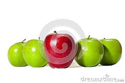 Straight On shot of a Big Red Apple Standing Tall in Front of Four Green Apples Stock Photo