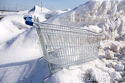 Horizontal view of shopping cart encased in ice after ice storm seen in snow bank Stock Photo