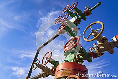 Horizontal view of a wellhead with valve armature. Oil and gas industry concept. Industrial site background. Toned Stock Photo
