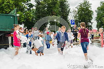 HORKI, BELARUS - JULY 25, 2018: Children of different ages play with airy white foam at the Rescue Service 112 holiday amid a crow Editorial Stock Photo