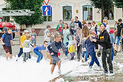 HORKI, BELARUS - JULY 25, 2018: Children of different ages play with white foam in the park at a party in summer day Editorial Stock Photo