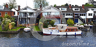 Waterside properties and old fashioned cruiser on the river Bure at Horning. Editorial Stock Photo