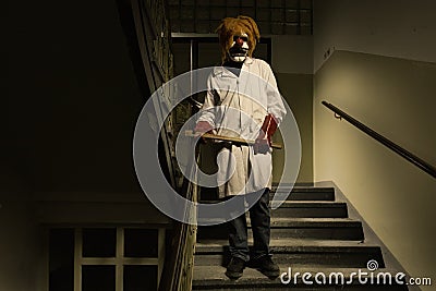 Serial murderer in creepy style of doctor clown on location of former hospital Stock Photo