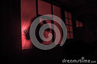Horror concept. The silhouette of a human with sprayed arms in front of a window. at night. Stock Photo