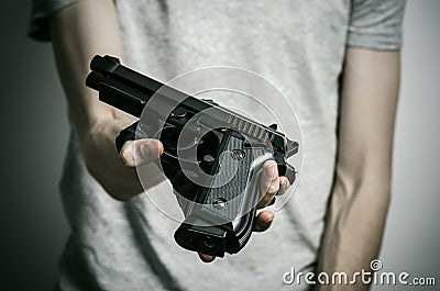 Horror and firearms topic: suicide with a gun on a gray background in the studio Stock Photo