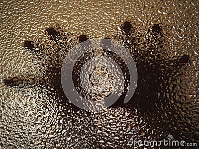 Horror hands. The shadow hands of human behind the glass. Corrugated textured glass through which children`s palms are visible Stock Photo