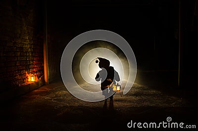 Horror scene of a scary children's ghost, Silhouette of scary baby doll on dark foggy background with light Stock Photo