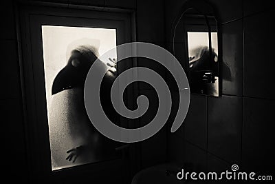 Horror silhouette of woman in window. Scary halloween concept Blurred silhouette of witch in bathroom. Selective focus Stock Photo