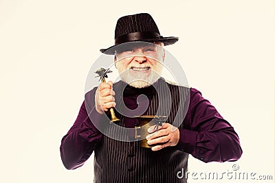 Horror themed Halloween party. Weird old grandfather with gray beard and spider. Preparing magic Halloween drink Stock Photo