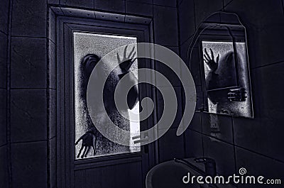 Horror woman in window wood hand hold cage scary scene halloween concept Blurred silhouette of witch Stock Photo