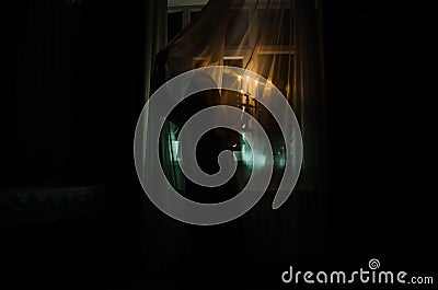 Horror woman in window wood hand hold cage scary scene halloween concept Blurred silhouette of witch. Selective focus Stock Photo