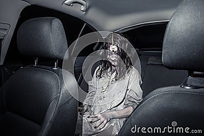 Horror zombie woman with bloody face in the car Stock Photo