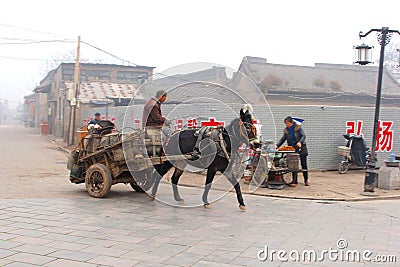 Traditional horse-drawn carriage in foggy walled town Pingyao, China Editorial Stock Photo
