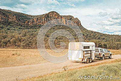 Horse float pulled by four wheel drive along a dirt road in rural Australia Stock Photo