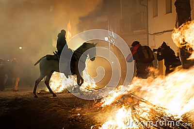 Horse with its rider rapidly breaking through the fire Editorial Stock Photo