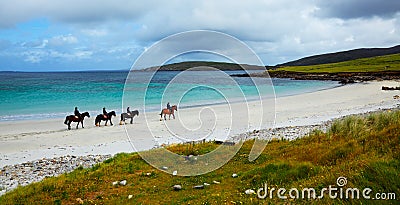 Horse and riders on the beach Stock Photo