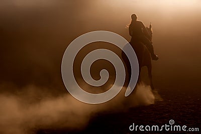 Horse riding in the dust Stock Photo