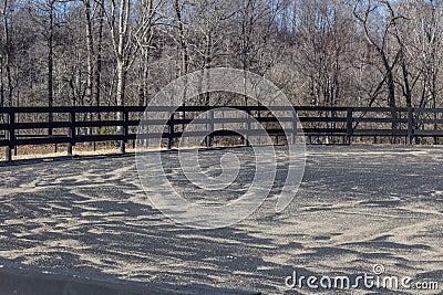 Horse riding ring with black fence, sand and rubber base Stock Photo