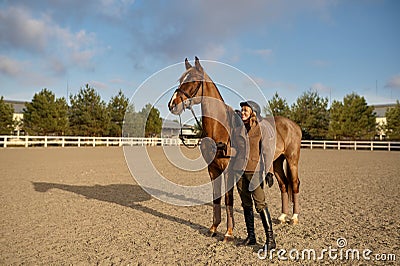 A horse trainer with her stallion outdoors in farm Stock Photo