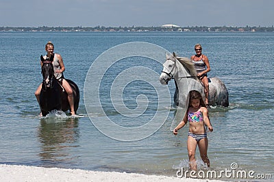 Beach Horseback Riders with Little Girl Editorial Stock Photo