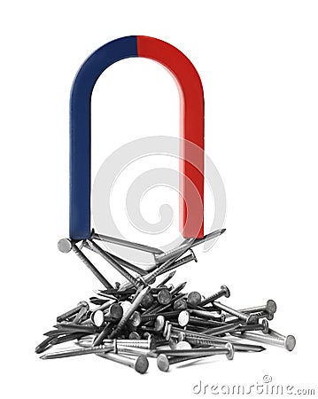 Horseshoe magnet attracting nails on white Stock Photo