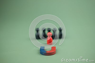 Horseshoe magnet with red peg doll. Talent, Human resources concept. Different and individual unique person Stock Photo