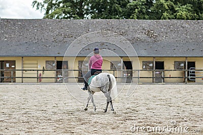 Horsewoman training on the white hors at the court Stock Photo