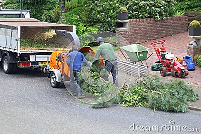 Gardeners work with a wood chipper, Netherlands Editorial Stock Photo