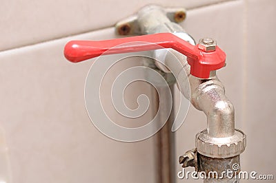 A hose plug quarter turn lever type ball valve water tap with red handle. Stock Photo