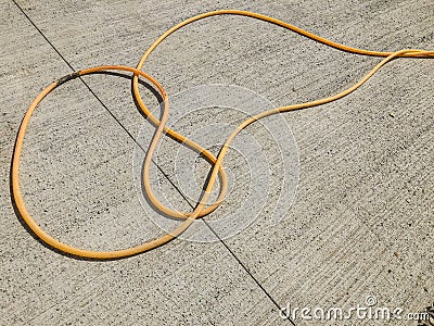 Hose for water lying on a concrete slab in the street. Material for repairs in an apartment is under construction Stock Photo