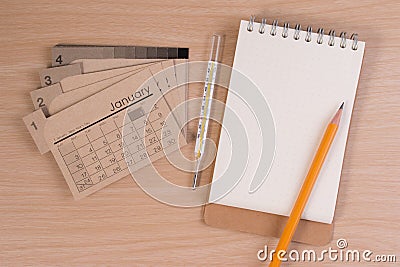 Hospital agenda on doctor table. Calendar thermometer and pencil on wooden table. Stock Photo